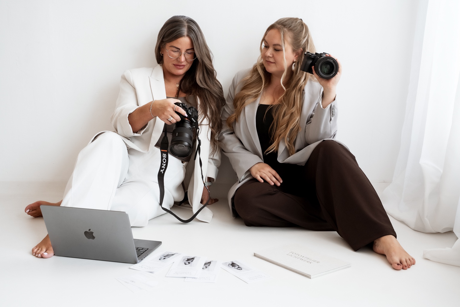 Nina und Julia mit Kameras und Laptop bei der gemeinsamen Bildauswahl